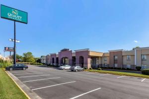 格林斯伯勒Quality Inn & Suites - Greensboro-High Point的建筑物前停车场的街道标志