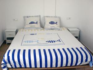 莱斯卡拉Holiday Home Michele by Interhome的一张带蓝色和白色条纹床单和枕头的床