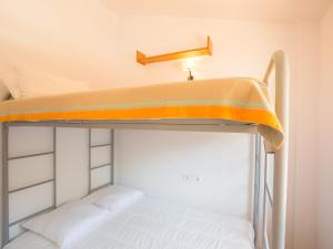 莱斯卡拉Holiday Home Michele by Interhome的双层床,上面有橙色和白色的毯子