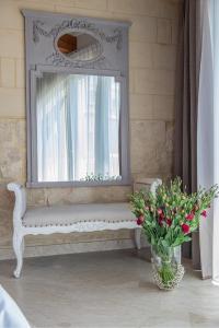 ŻebbuġLulu Boutique Hotel的白色长凳,有窗和花瓶