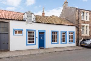 安斯特拉瑟Coastal Cottage - Cellardyke Anstruther的蓝色的白色房子,设有蓝色的门