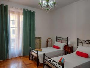 米兰Bnbook-Villa Molinari的一间卧室配有两张床和吊灯。