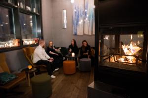 朗伊尔城斯瓦尔巴德酒店 | 普法瑞恩的一群人坐在一个带壁炉的房间里