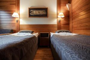 易拉斯加威拉普兰萨迦酒店的木墙客房的两张床