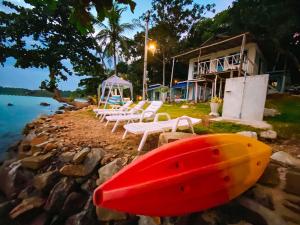 象岛秘密花园家庭度假屋的一组椅子和一个带冲浪板的房子