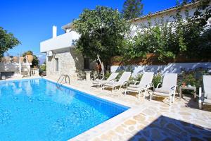 卡米拉日Villa Oasis的一个带椅子的游泳池以及一座房子