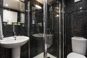 特维德上游的贝里克Manor House Hotel Holy Island的浴室配有卫生间、盥洗盆和淋浴。