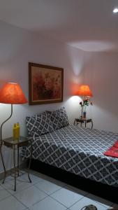 萨尔瓦多CASACOMPART itapuã的一间卧室配有一张床和两张台灯。