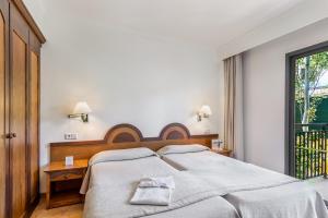坎皮卡福特Vell Mari Hotel & Resort的一间卧室设有一张大床和一个窗户。