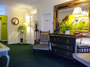 凯恩莱安嘉乐威兰斯酒店的一间设有梳妆台、两把椅子和镜子的房间