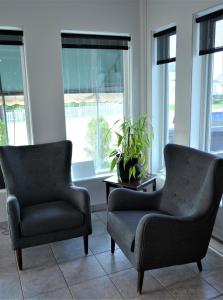 福里斯特维尔Motel Quatre Saisons的带窗户的客房内配有两把椅子和一张桌子