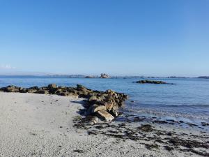 桑泰克Gîte bord de mer的海水中有些岩石的海滩