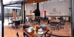 伊瓜苏港Ingá Apart & Suites的一间在房间内配有桌椅的餐厅
