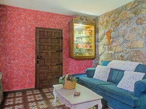 加拉帕加尔Rural apartment with Spa and common areas的客厅设有蓝色的沙发和石墙