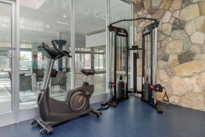 卡尔加里Super 8 by Wyndham Macleod Trail Calgary的健身房设有两台跑步机和石墙