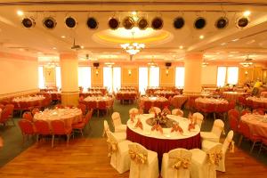 诗巫百乐门诗巫大酒店的一个带桌椅和桌子的大型宴会厅
