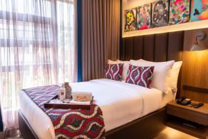 马尼拉UNWND Boutique Hotel Makati的酒店客房设有床和窗户。
