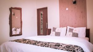 日惹nDalem Joglo Krawitan Syariah的一间卧室配有一张带白色床单和镜子的床