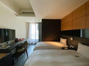 台南台南圣旺商旅的酒店客房配有两张床和一张书桌