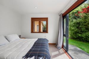 图朗伊Waters Edge Retreat - Motuoapa Holiday Home的一间卧室设有一张床和一个窗口