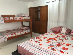 卡塔赫纳HOSPEDAJE CARIBE EXPRESS的一间卧室配有两张床和一张双层床。