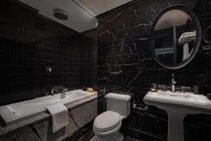 河内La Sinfonía del Rey Hotel & Spa的一间带卫生间、水槽和镜子的浴室