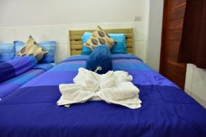 素辇府KT Knight Hotel的一张蓝色的床,上面有白色的毛巾