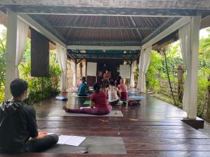 坎古KTS Balinese Villas的一群坐在地板上参加瑜伽课的人