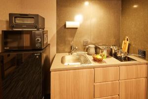 东京MONday Apart Premium AKIHABARA的厨房配有水槽和微波炉