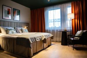 特隆赫姆Quality Hotel Prinsen的卧室配有床、椅子和窗户。