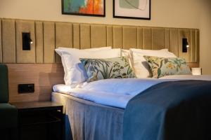 特隆赫姆Quality Hotel Prinsen的一间卧室配有带白色床单和枕头的床。
