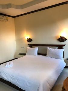 色军Siwasom Resort Sakon Nakhon的卧室配有一张带两个枕头的大白色床