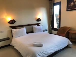 色军Siwasom Resort Sakon Nakhon的卧室配有一张大白色床和窗户