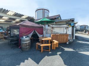 笛吹市Tabist Hotel Nizi Fuefuki Misaka的配有桌椅和桶子的帐篷