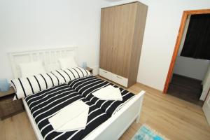 蒂豪尼Aquilo Apartmanok的一间卧室配有一张黑白条纹的床