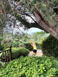 穆然池塘乡间别墅酒店的站在花园中树下的一个女人