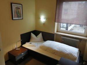 奥格斯堡法尔克奥格斯堡高德纳酒店的一间小卧室,配有床和窗户