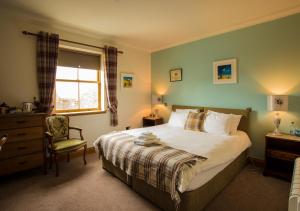 埃伦港伊斯雷酒店的卧室配有床、椅子和窗户。