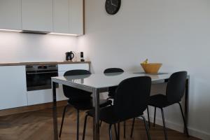 奥尔什丁Apartamenty Asapartment Stockholm的厨房配有桌子和四把椅子