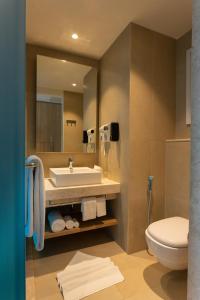 班加罗尔Holiday Inn Express & Suites Bengaluru Old Madras Road, an IHG Hotel的一间带水槽、卫生间和镜子的浴室