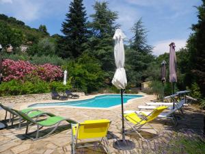 Villeneuve马斯杜卡卓尼尔酒店的游泳池旁的游泳池配有椅子和遮阳伞
