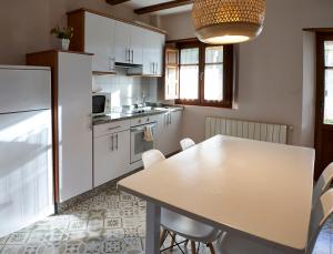 GalendeEl Mirador de Sanabria的厨房配有白色橱柜和桌椅
