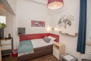 诺德奈Haus Neunaber的一间设有红色床和电视的小卧室