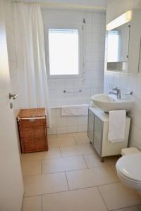 洛桑Modern, bright and spacious 3 bedrooms 2 bathrooms的白色的浴室设有水槽和卫生间。