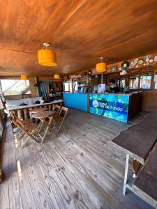 德尔迪阿布罗角Mar de Fondo Hostel的餐厅铺有木地板,设有带桌子的柜台。