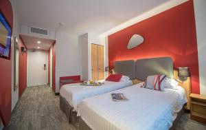 卡罗普罗莫特尔酒店的酒店客房设有两张床和红色的墙壁。