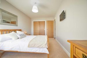 锡豪西斯Host & Stay - Sunflower Cottage的卧室配有白色的床和平面电视。