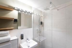 慕尼黑Munich Rooms Hotel的带淋浴和盥洗盆的白色浴室