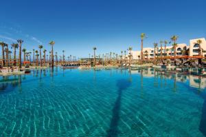 塔哈佐特Hotel Riu Palace Tikida Taghazout - All Inclusive的度假村内一座种有棕榈树的大型游泳池