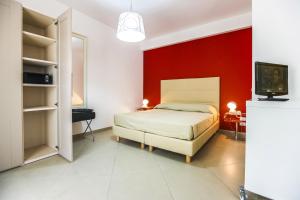 特拉帕尼西窗酒店的一间卧室设有一张床和红色的墙壁